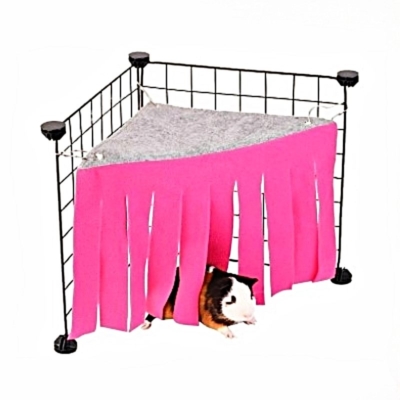 Pink fleece corner tent hideout clipped into the corner of a guinea pig cage.
